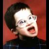 Kid making a goofy face in glasses