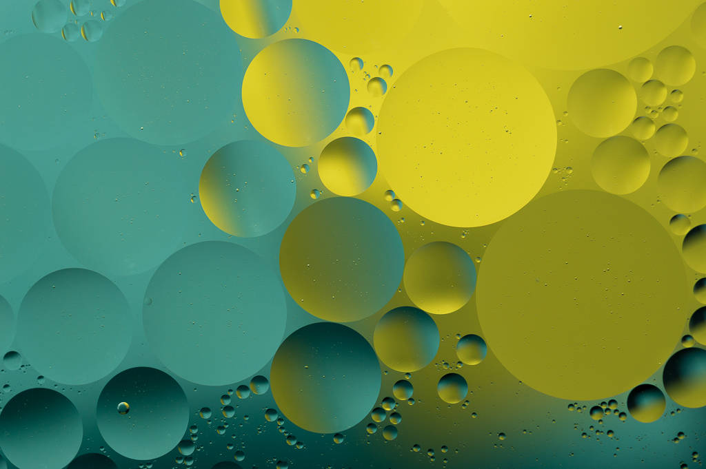 Macro oil-and-water bubbles in teal and yellow hues