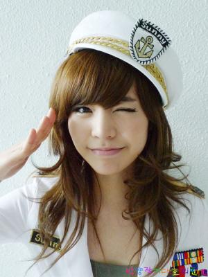 Winking girl in sailor cap strikes a peace sign