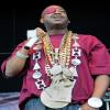 Rapper on stage rocking gold chains and a mic