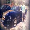 Guy posing with a Mustang, streetside snapshot