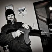 Two guys posing with a rifle, black-and-white shot